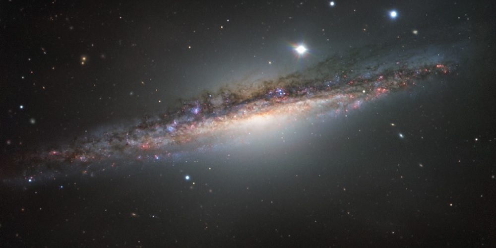 Deze kleurrijke opname, gemaakt met ESO’s Very Large Telescope toont NGC 1055 in het sterrenbeeld Cetus (Walvis). De middellijn van dit forse sterrenstelsel is mogelijk tot wel vijftien procent groter dan die van onze Melkweg.