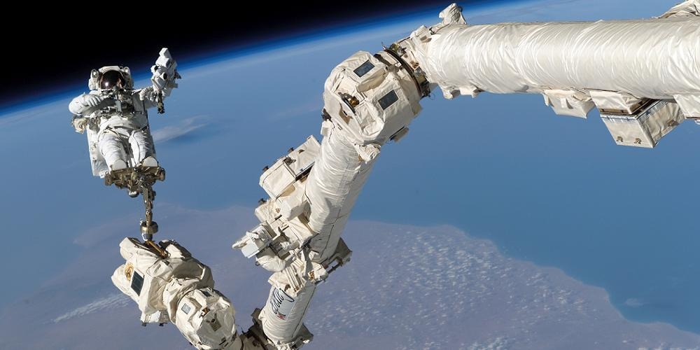 Astronaut Steve Robinson bevindt zich aan de Canadarm2 robotarm