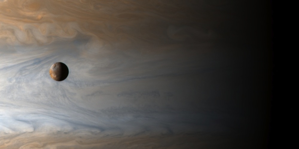 De maan Io voor de gigantische planeet Jupiter