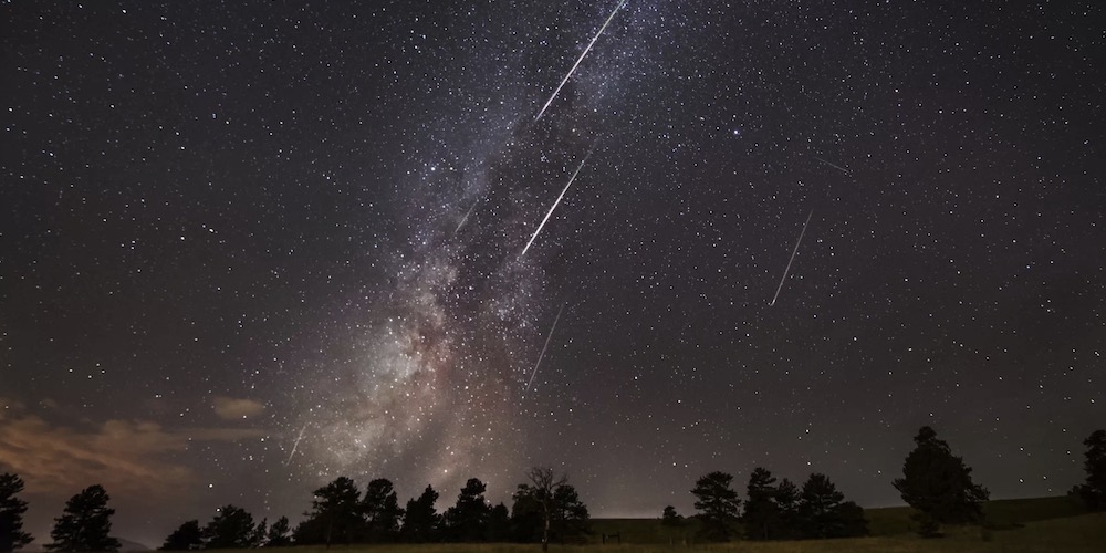 Prachtige opname van enkele meteoren aan de nachtelijke sterrenhemel. 